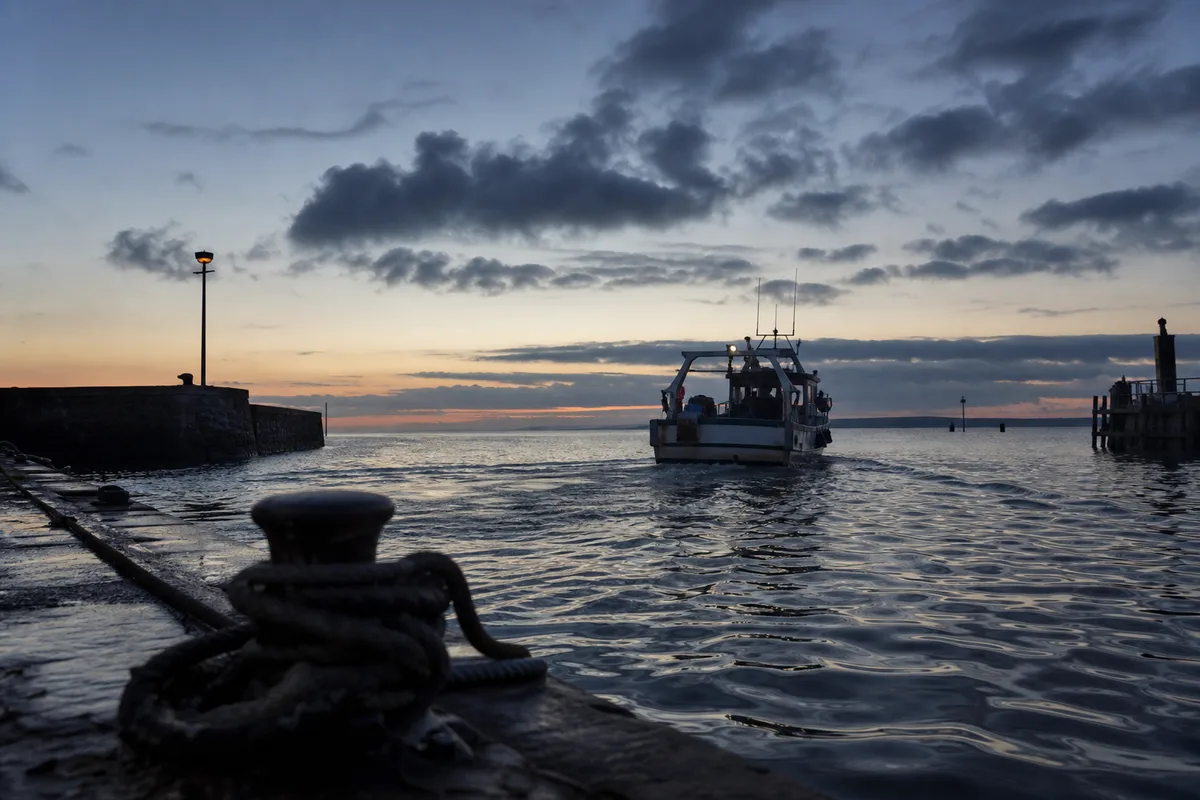 Bateau de pêche quittant un port du bassin d&rsquo;Arcachon au petit matin